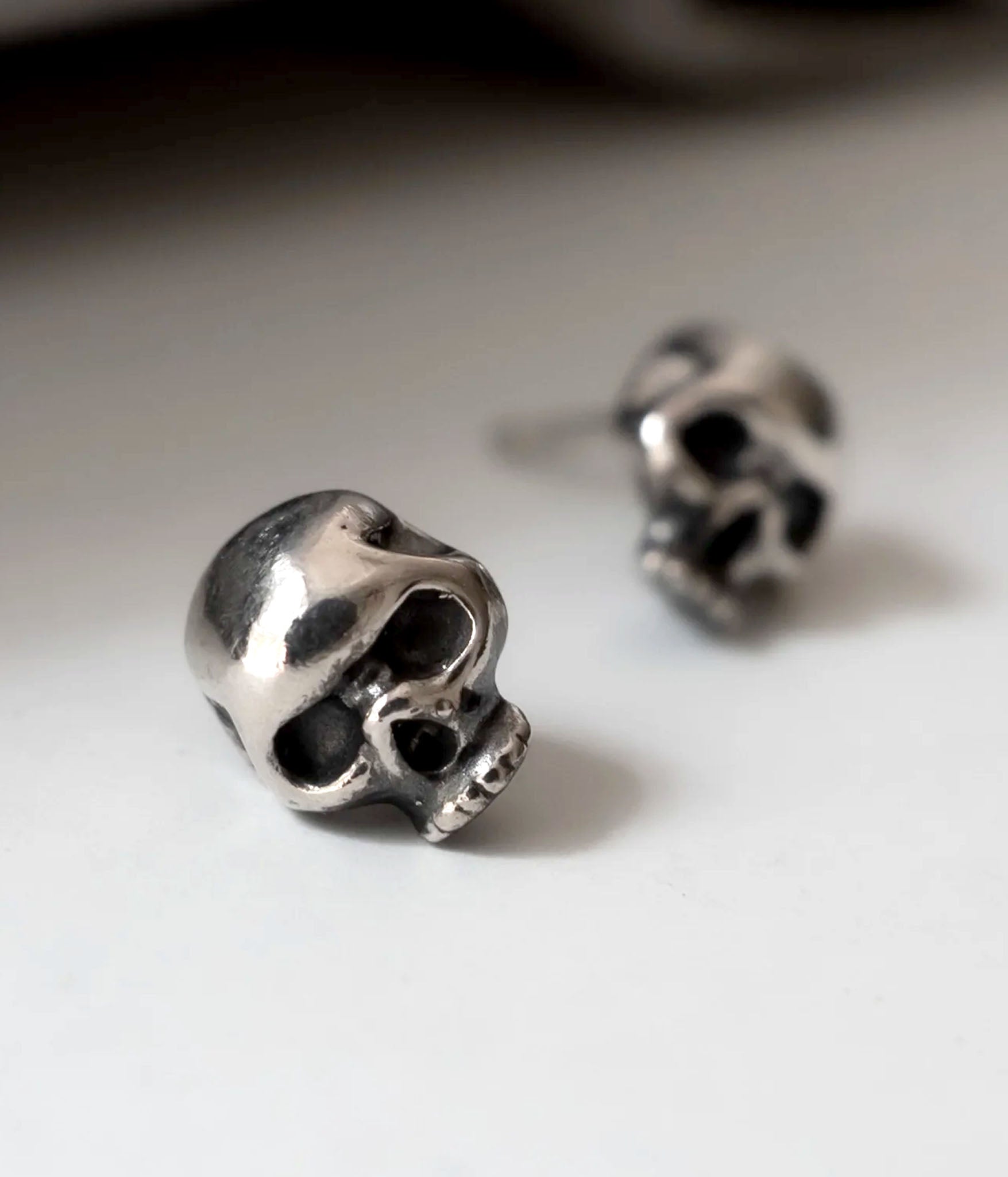 Close up shot of sterling silver skull stud earring