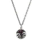 Silver necklace with a round pendant on a white background