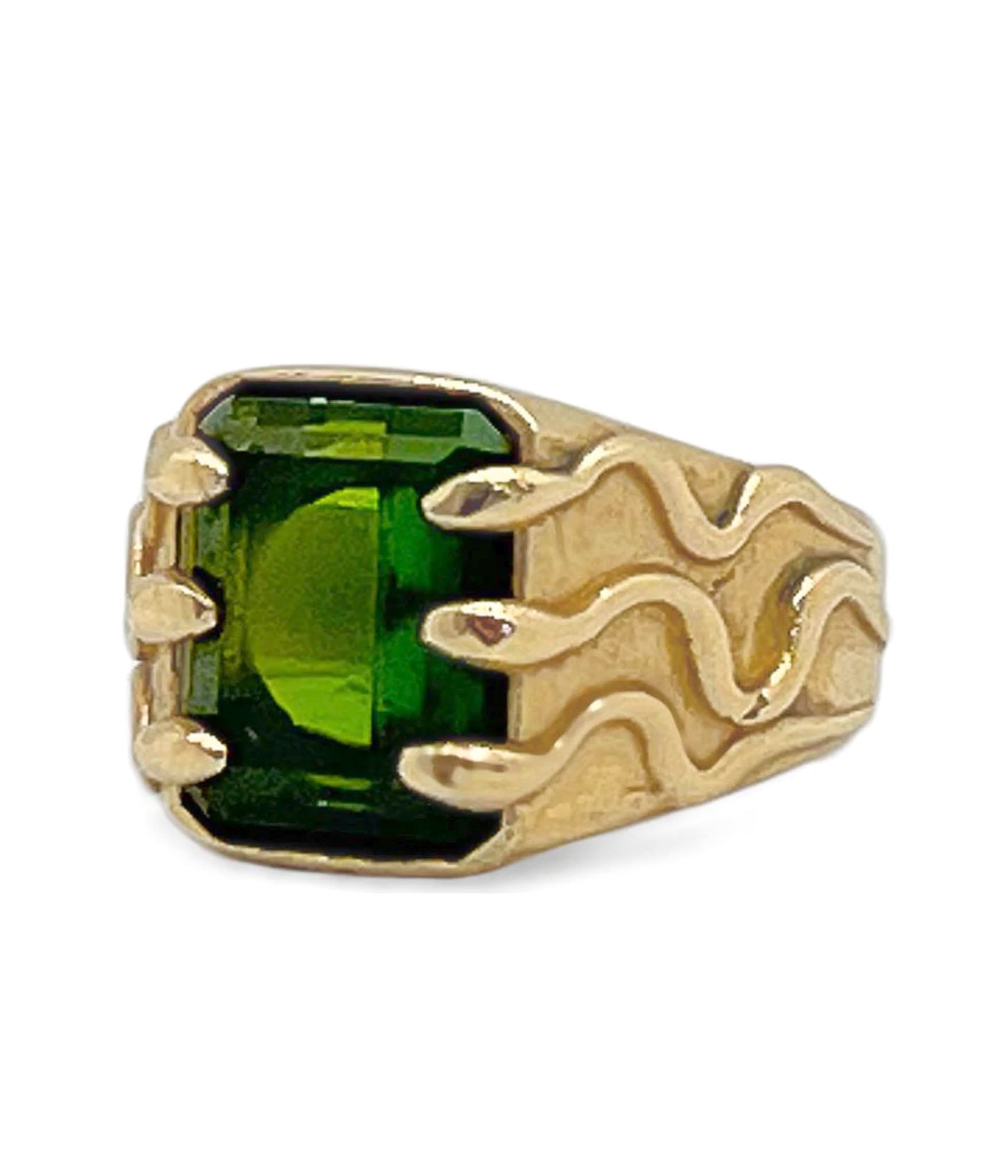 Gold ring with a green gemstone on a white background