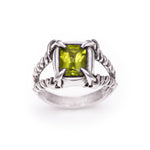 Silver ring with a green gemstone on a white background