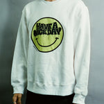 White sweatshirt with a smiley face and 'Have a nice day' text on a gray background
