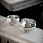 Two silver rings on a textured surface with a blurred background