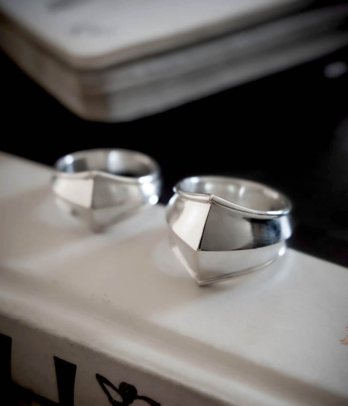 Two silver rings on a textured surface with a blurred background