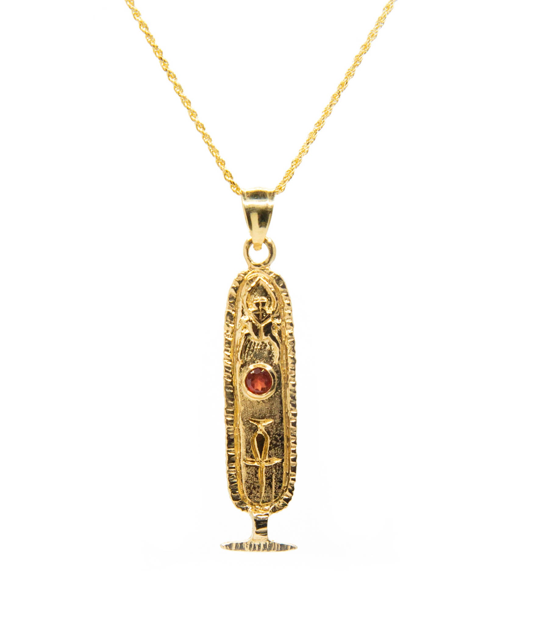 Gold pendant necklace with a central red gemstone on a white background