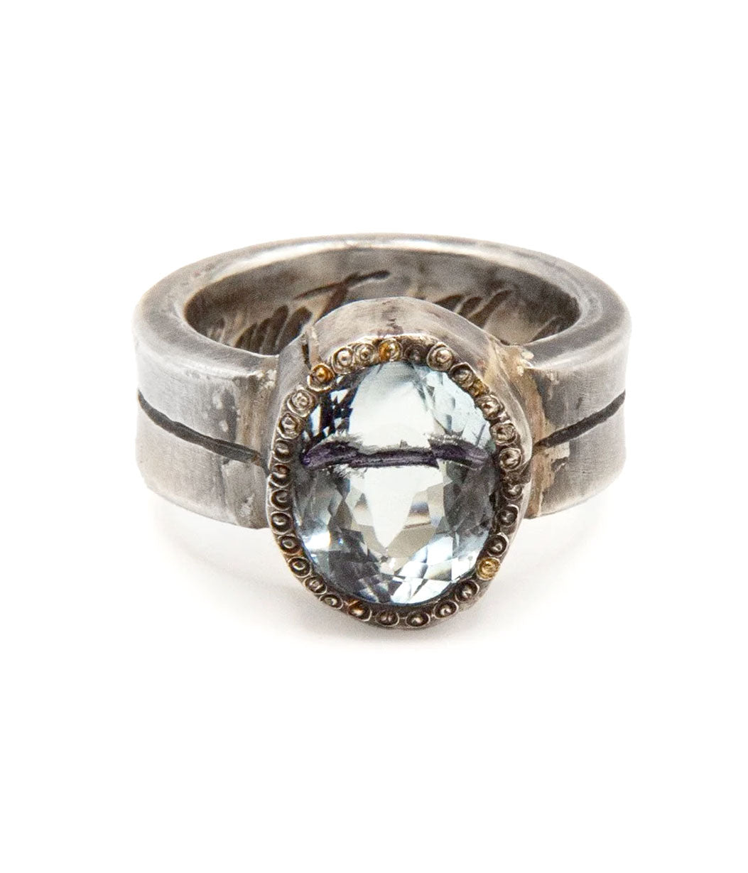 Silver ring with a blue gemstone on a white background