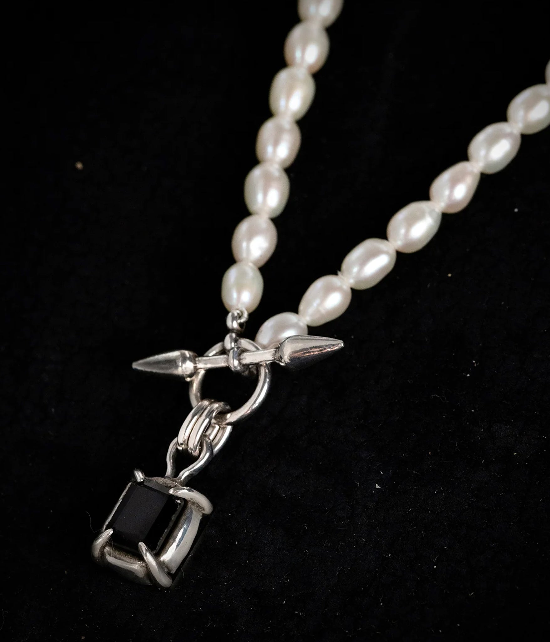 close up shot of Pearl necklace with a square black onyx pendant and spike toggle clasp, handcrafted in sterling silver
