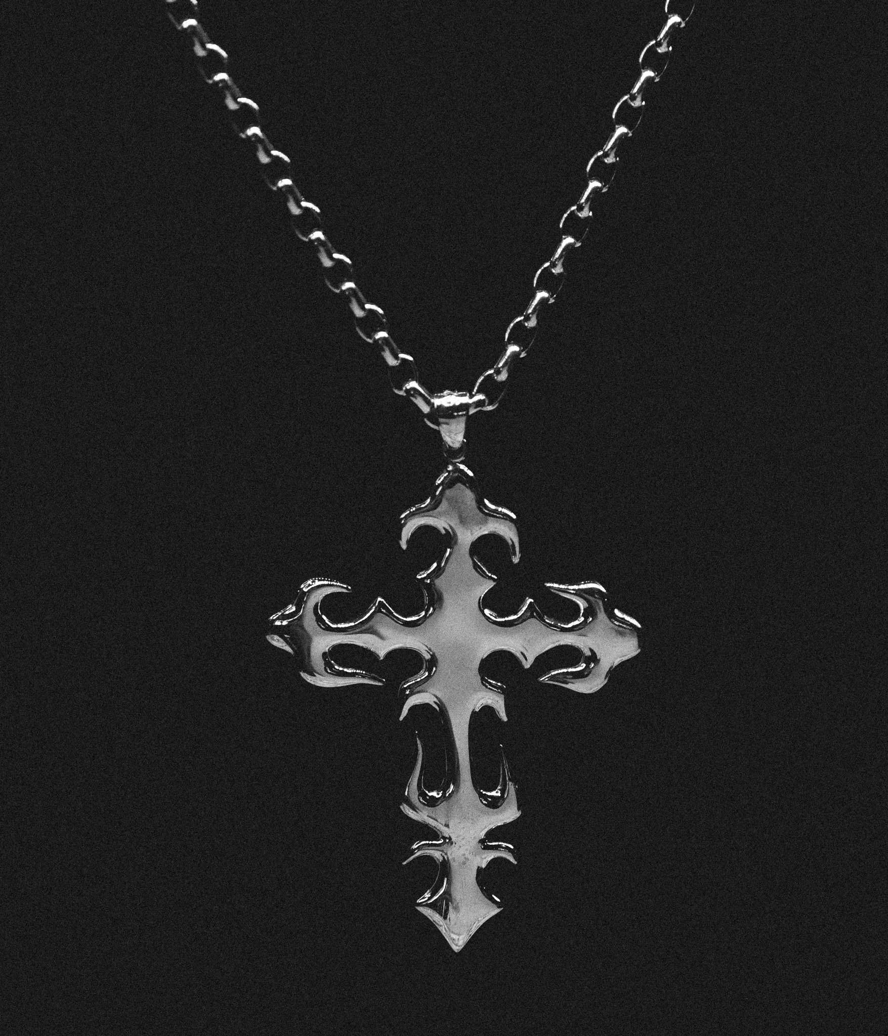 Silver cross pendant necklace on a black background