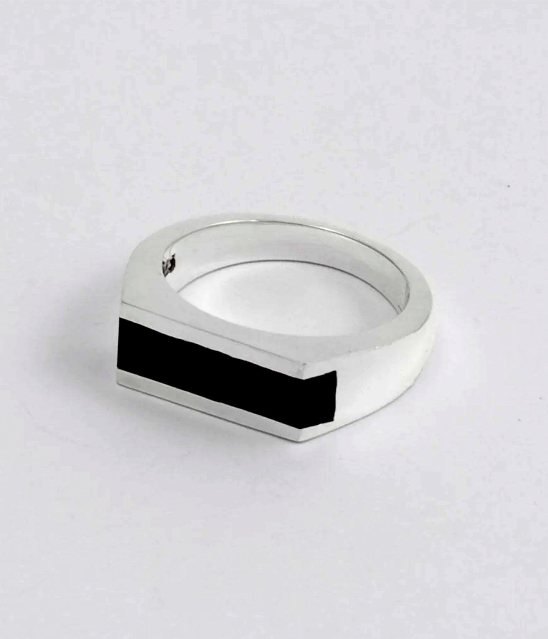 Silver ring with a black bar design on a white background