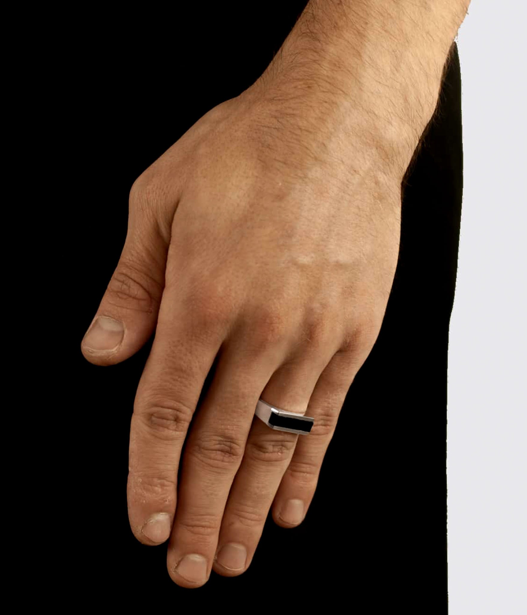 Hand wearing a silver ring on a black and white background