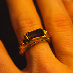 Gold ring with a red gemstone on a finger