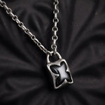 Silver padlock-shaped pendant on a chain against a black textured background
