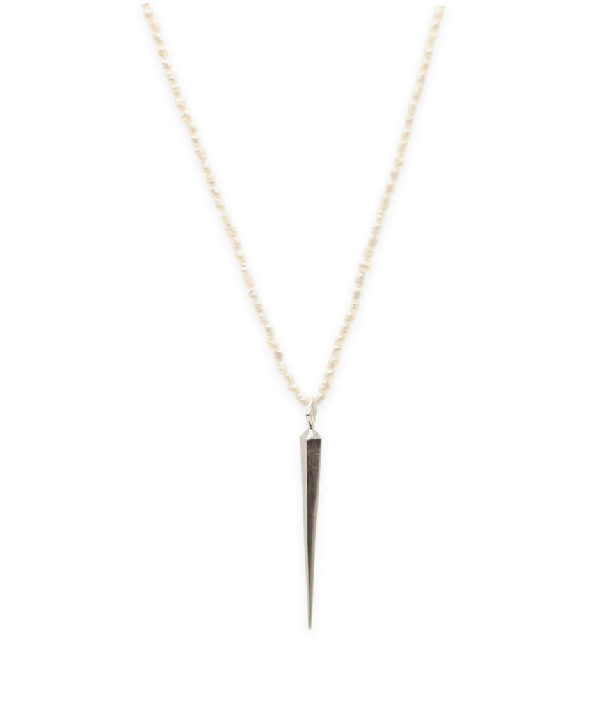 Necklace with a small, dark pendant on a thin chain against a white background