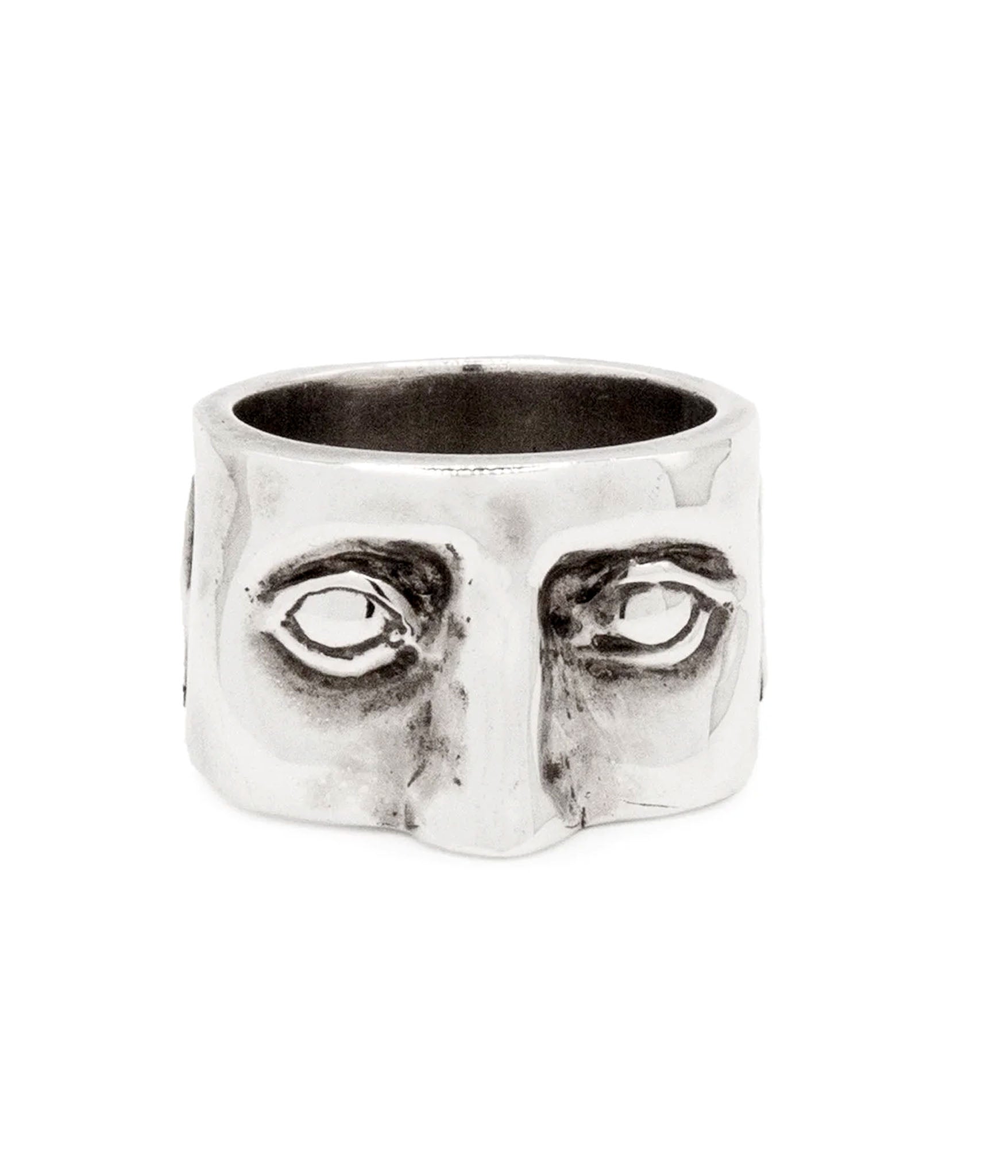 Silver ring with face design on a white background