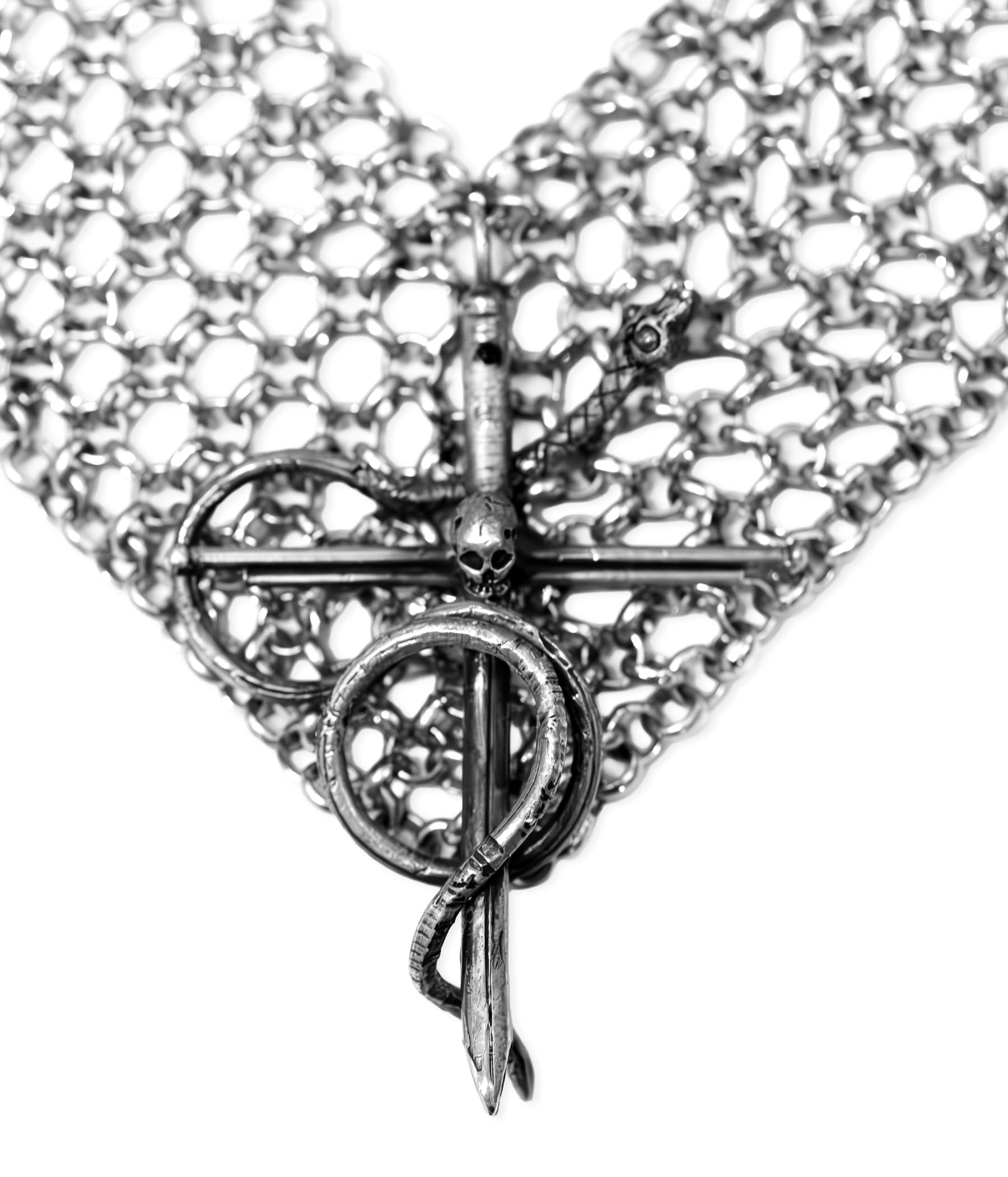 Close-up of a silver chainmaille bracelet with intricate design on a white background