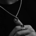 Close-up of a hand wearing multiple silver rings with a dark background