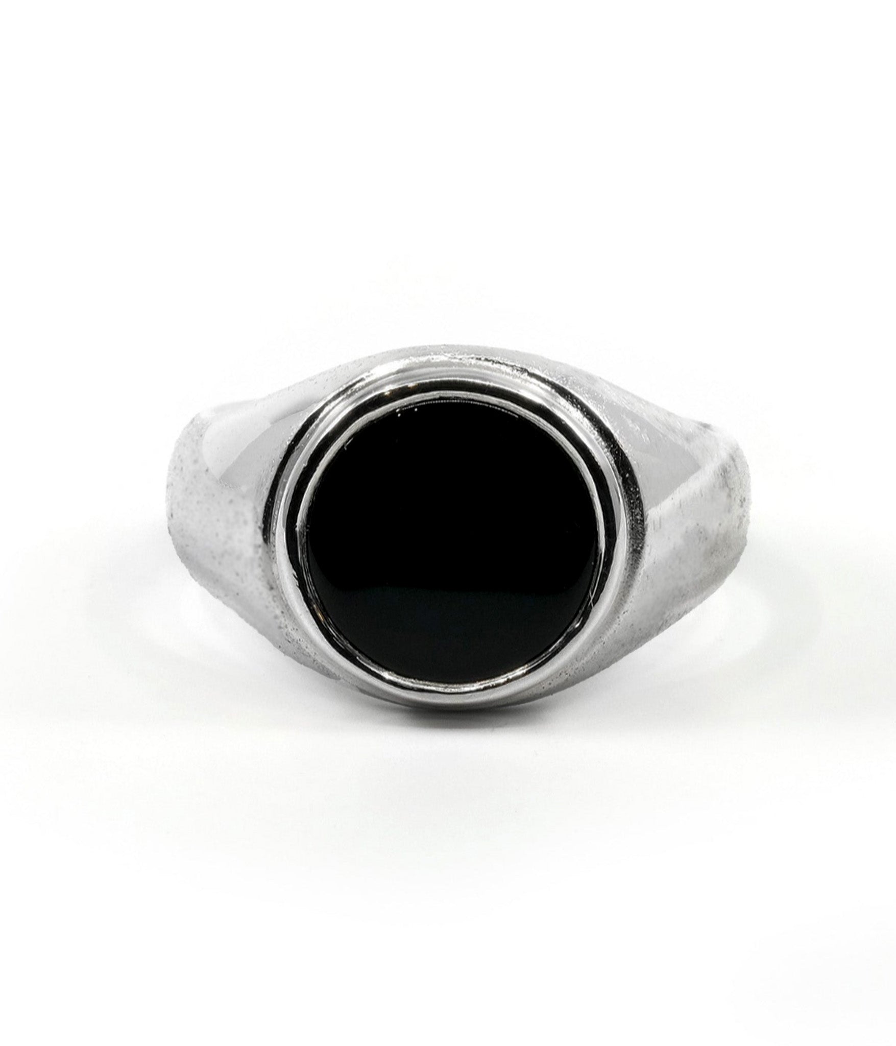 Silver ring with a black stone on a white background