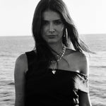Black and white photo of a woman standing by the ocean