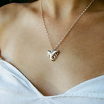 Necklace with a paw print pendant worn by a person