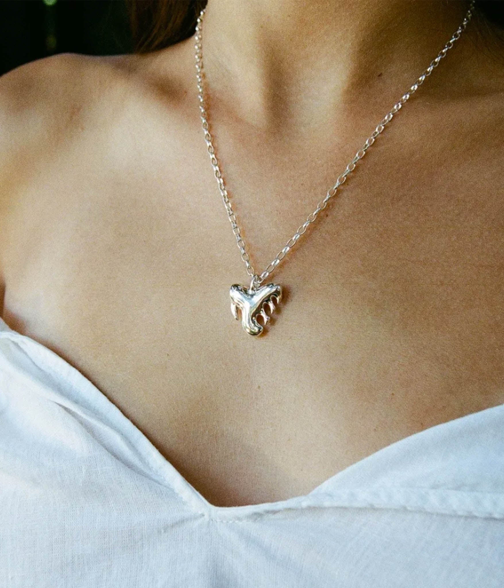 Necklace with a paw print pendant worn by a person