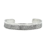 Silver textured bracelet on a white background
