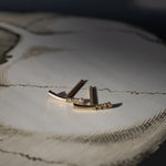 editorial shot of bar earrings on white table
