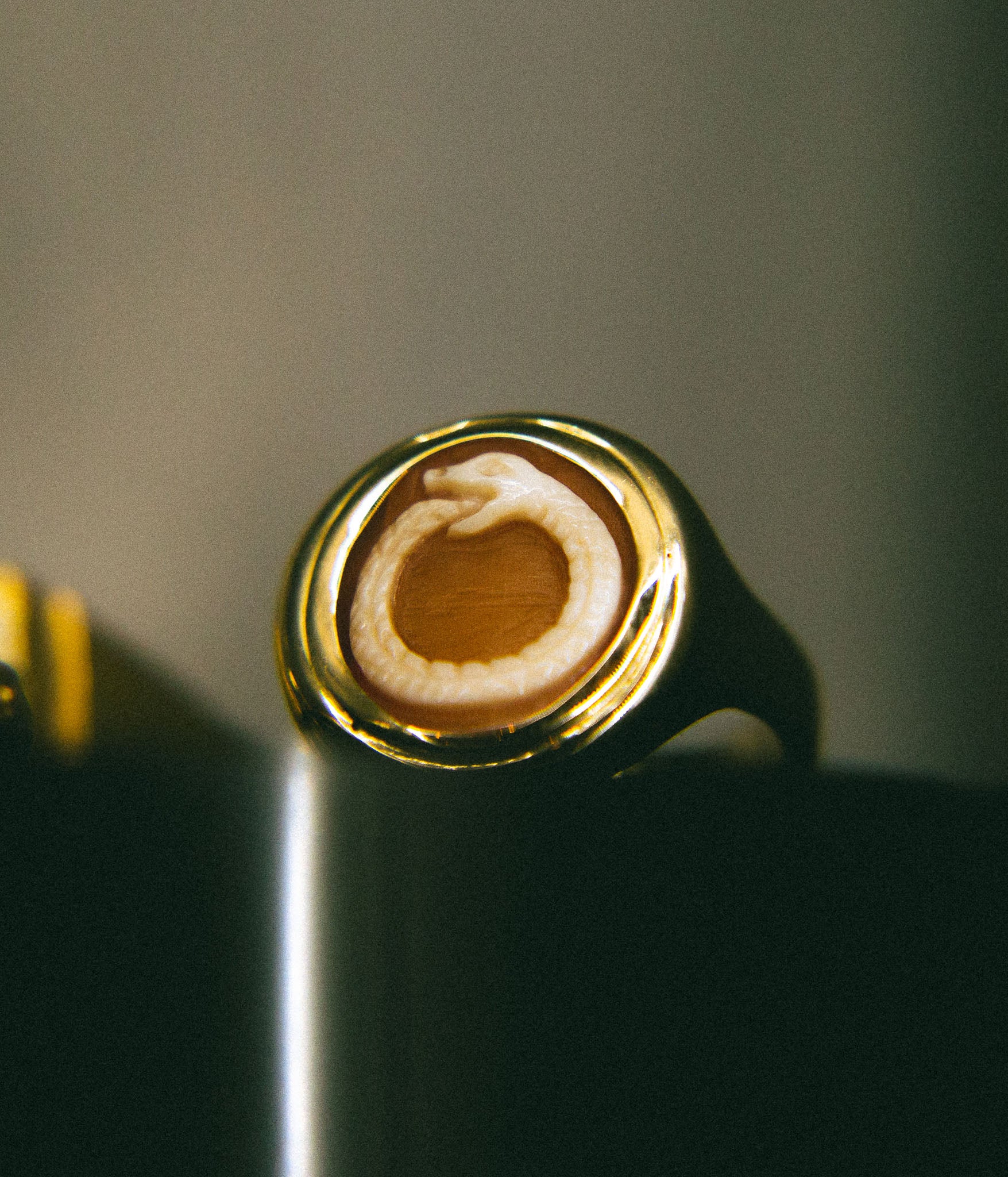 Gold ring with a circular design on a dark background