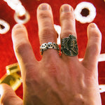 Hand wearing two rings with a red background