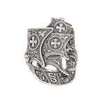 Silver ring with intricate designs on a white background