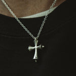 Silver cross necklace on a black background