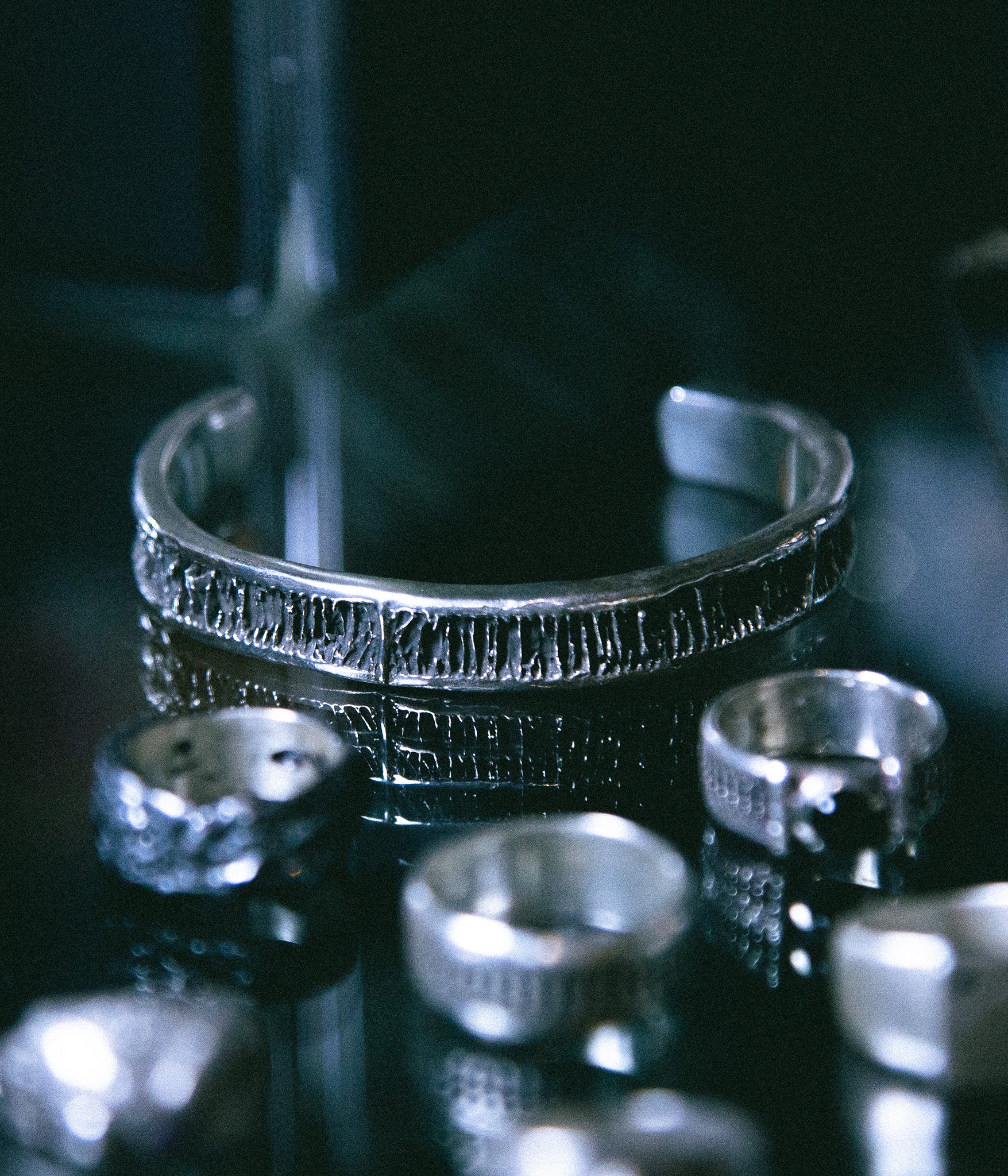 Silver ring on a reflective surface with a dark background