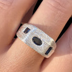 Silver ring with black stones on a finger