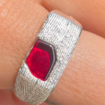 silver ring with ruby on finger
