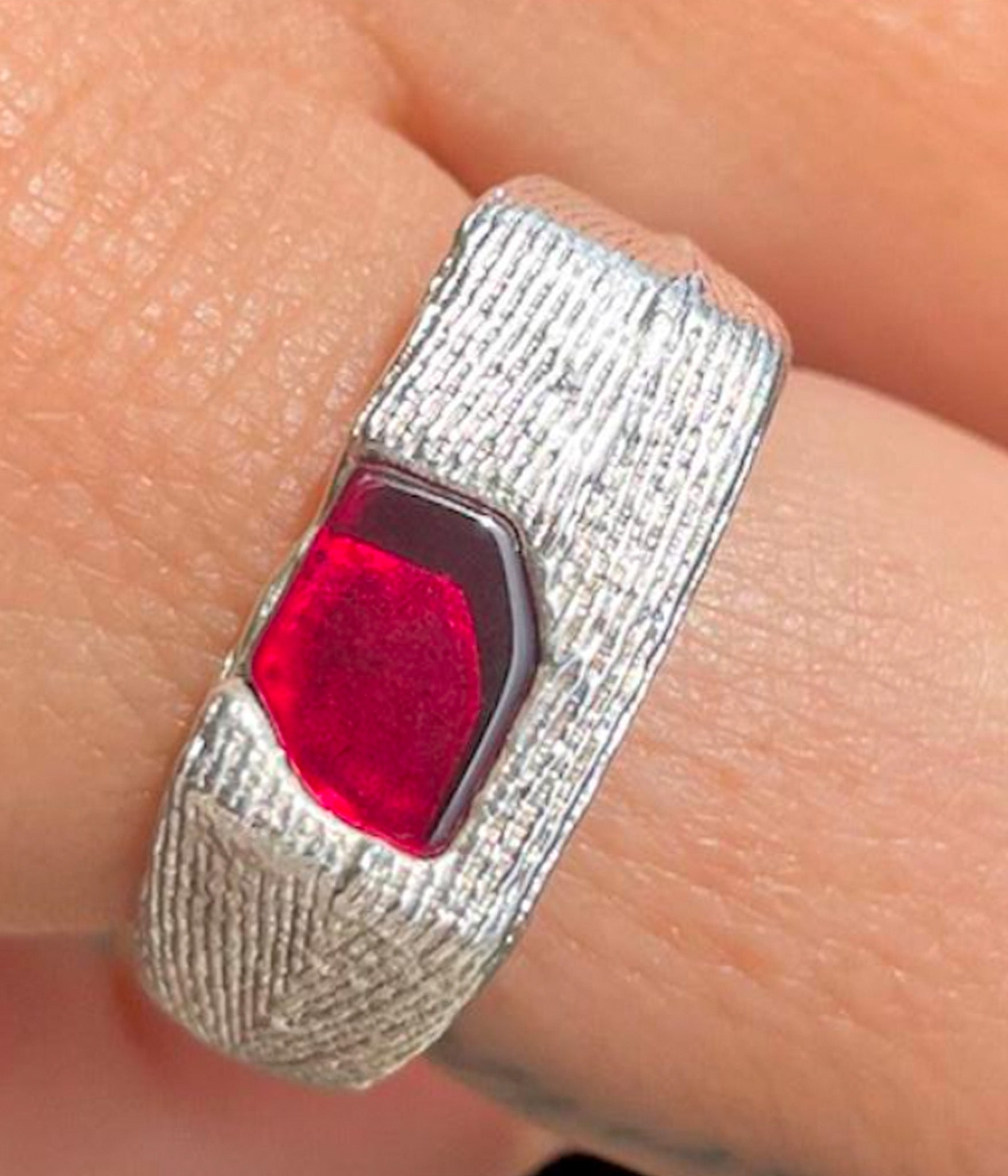 silver ring with ruby on finger