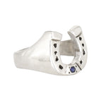 Silver horseshoe-shaped ring with a blue gemstone on a white background