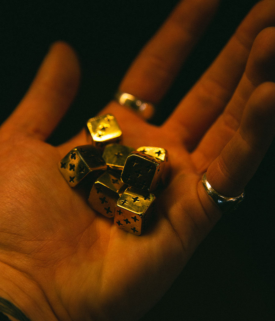 Gold dice with star patterns on a person's palm