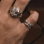 Close-up of a hand wearing two silver rings with a textured design.