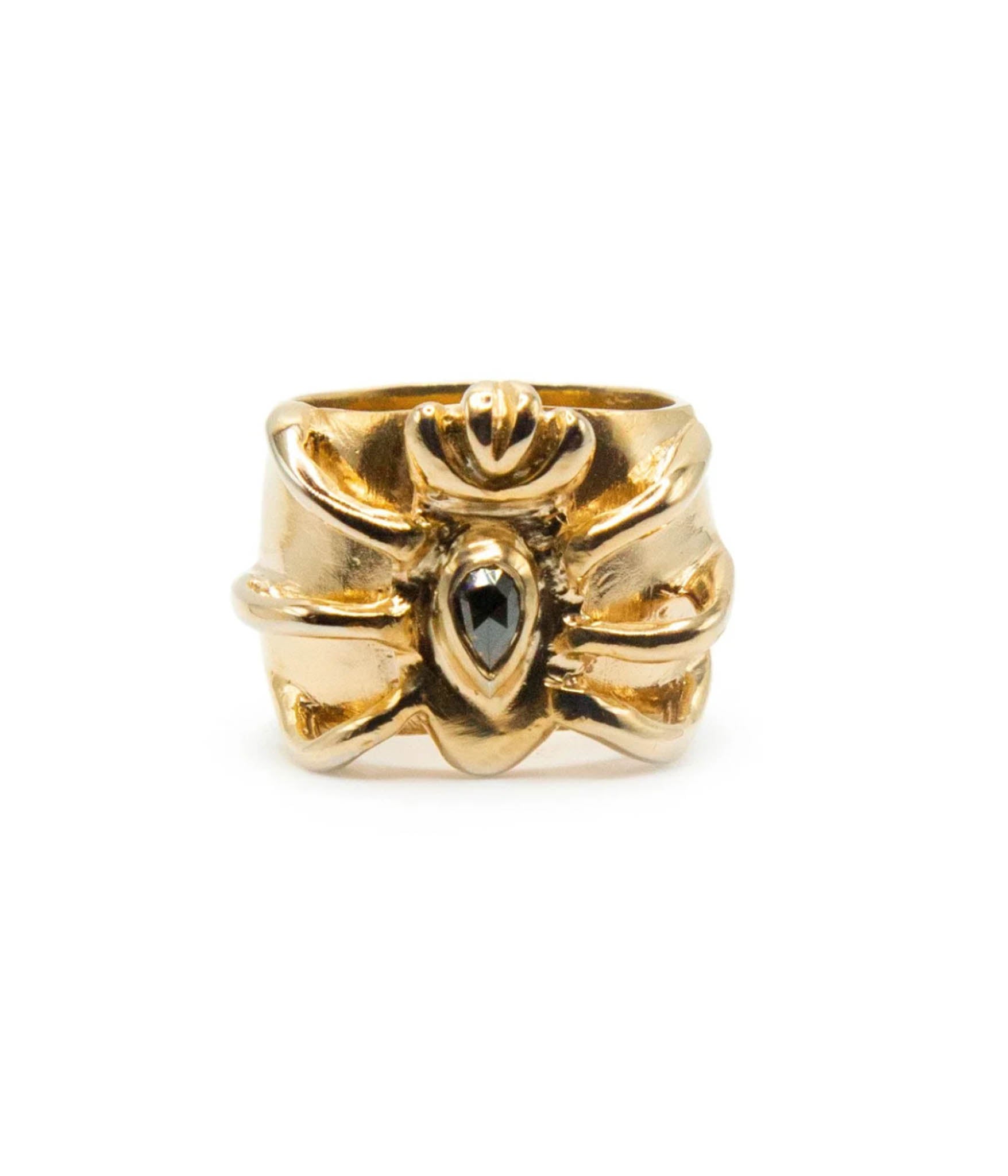 Gold ring with a black gemstone on a white background