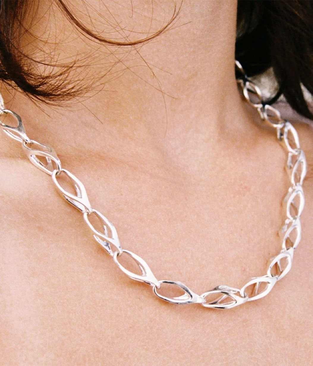 Silver chain necklace worn around the neck