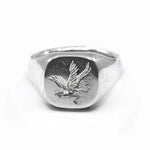 Silver ring with an eagle emblem on a white background