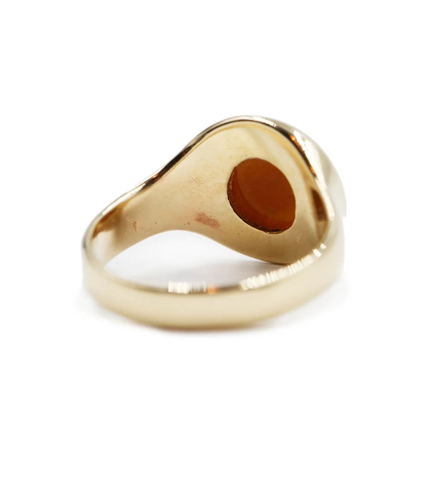 Gold ring with a central brown stone on a white background