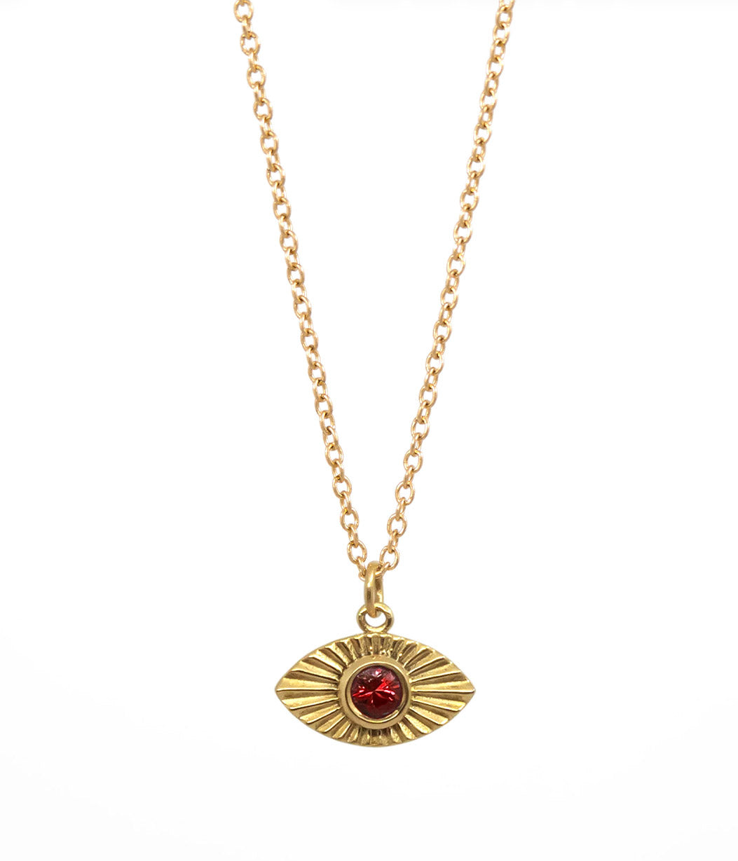 Gold necklace with a red gemstone eye pendant on a white background