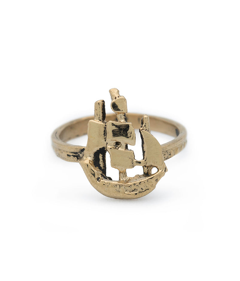 Gold ring with a ship design on a white background