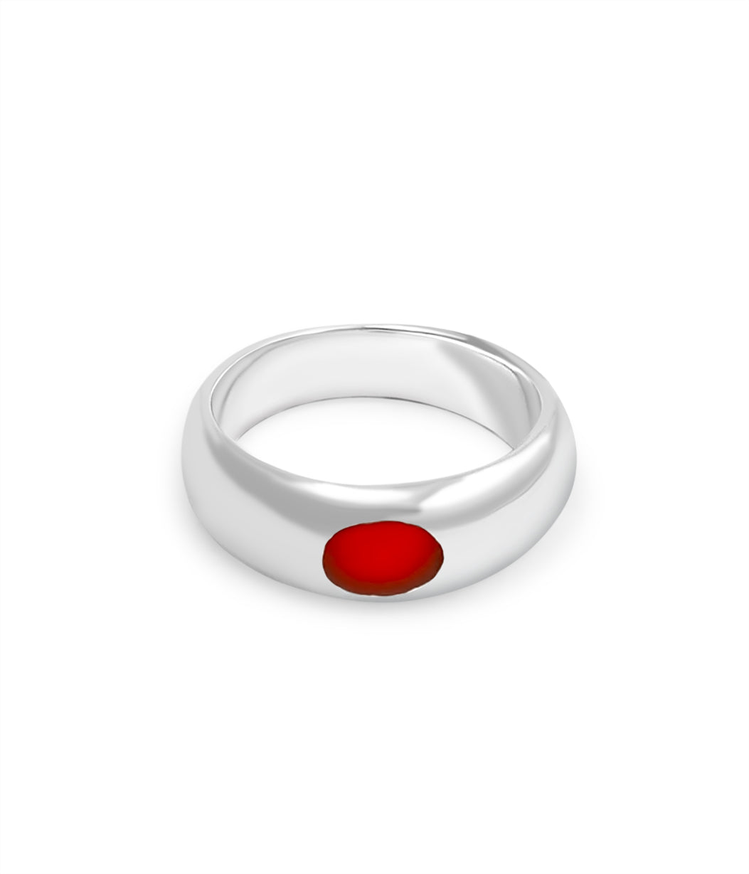 Silver ring with a red stone on a white background