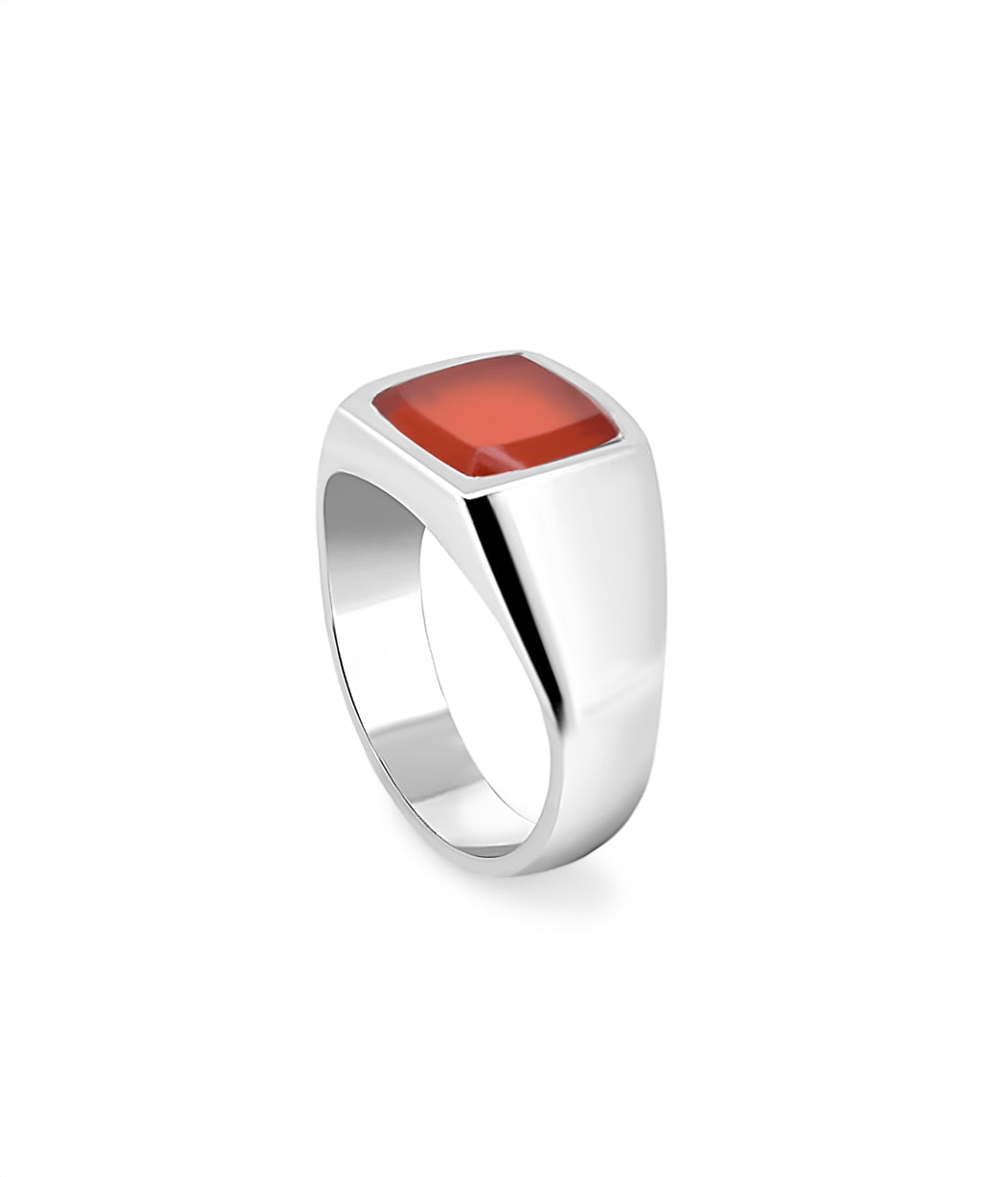 Silver ring with a red stone on a white background