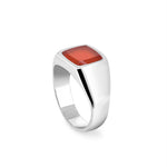 Silver ring with a red stone on a white background