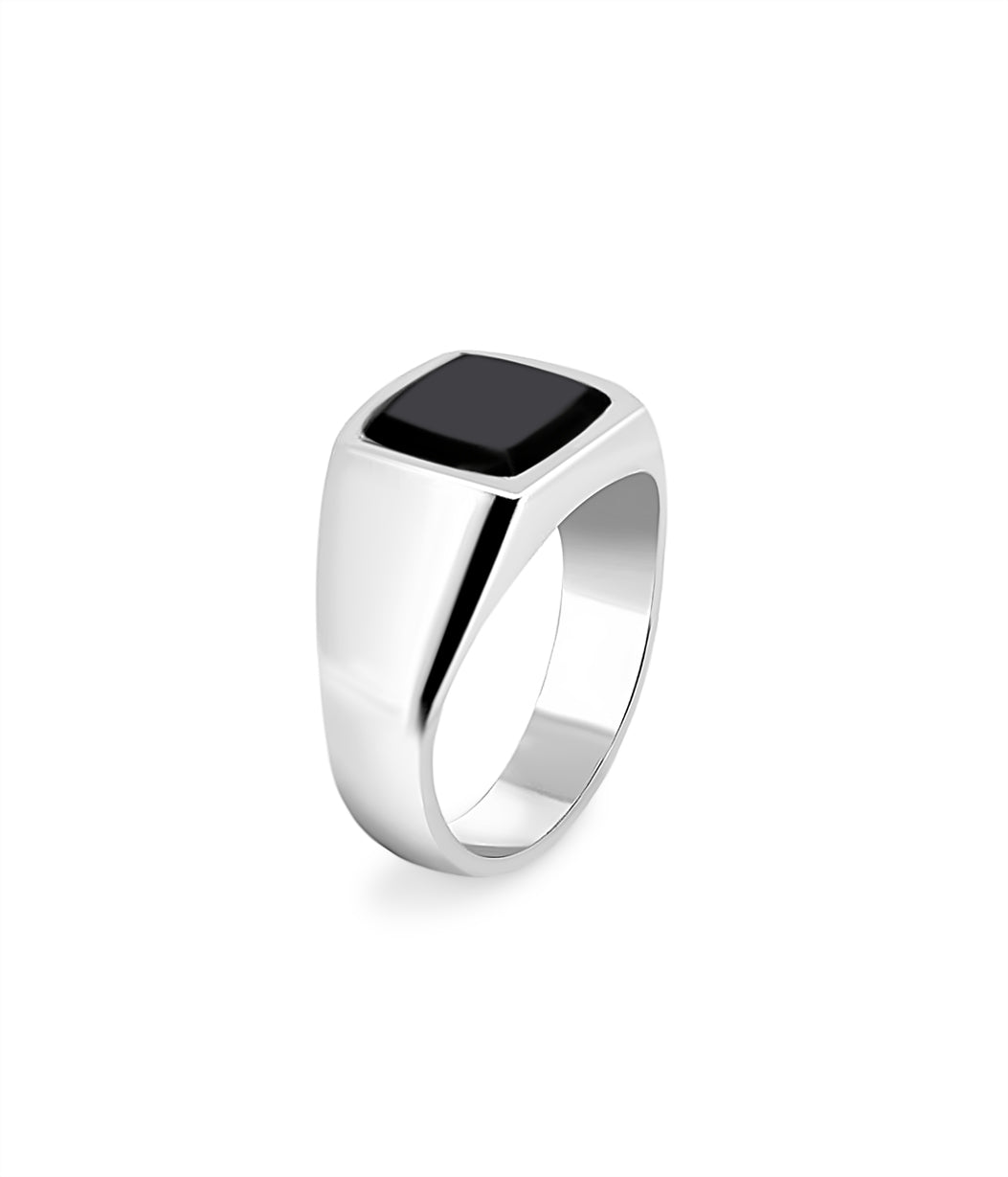 Silver ring with a black stone on a white background