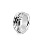 Silver ring with a wavy design on a white background