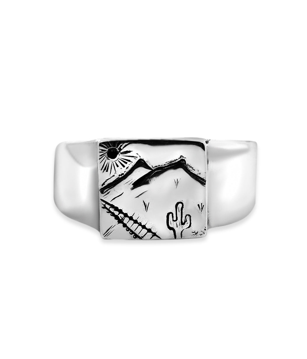 Silver ring with a black and white desert scene design on a white background