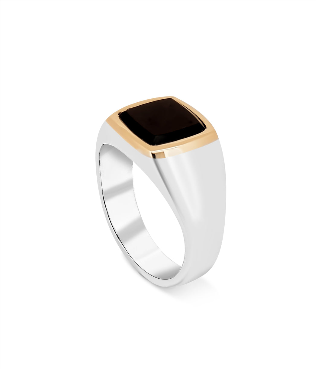 Ring with black stone and gold accents on a white background