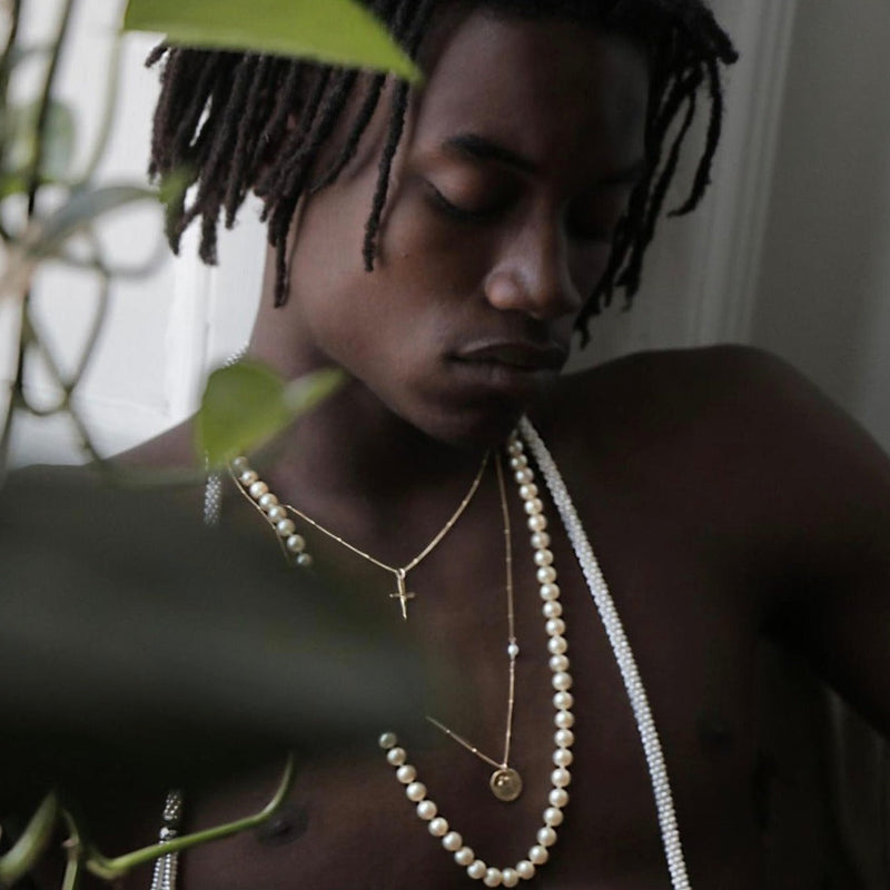 Person wearing pearl necklaces with a blurred background